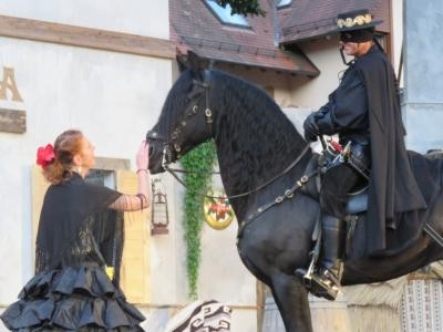 Szene aus dem Stück Zorro mit dem auf einem Pferd sitzenden Zorro und Isabella