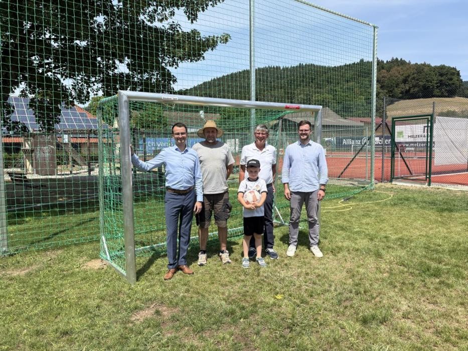 Das Bild zeigt von links Bürgermeister Michael Moser, Bauhofleiter Mathias Schmidt, Ortsvorsteher Werner Göhrig mit Enkel Jona und Bauamtsleiter Simon Grimm auf dem Bolzplatz