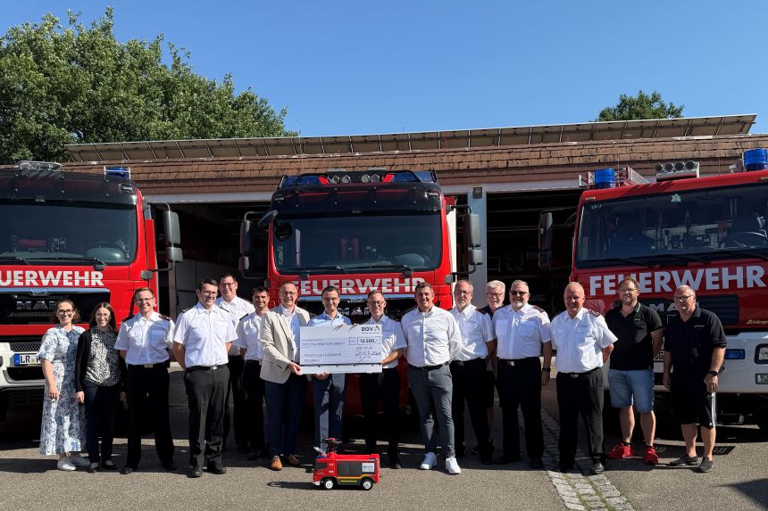 Gruppenbild vor Feuerwehrfahrzeugen bei der Spendenübergabe