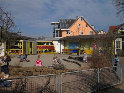 Bild der  KiTa mit Kindern, die im Hof spielen 